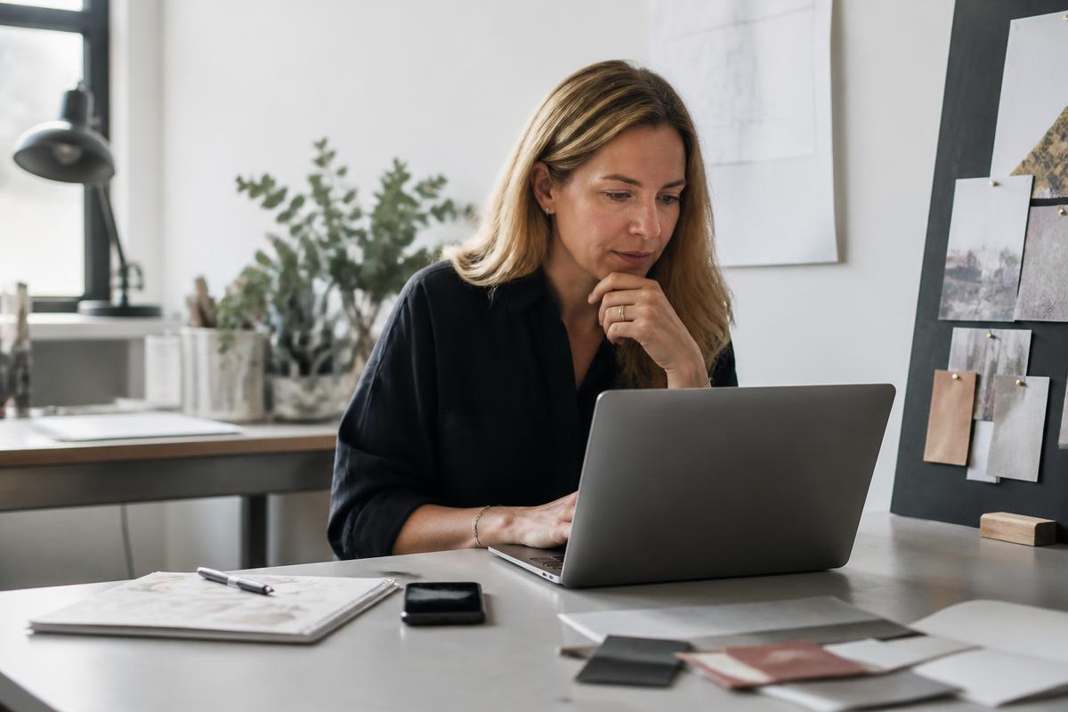 Independent consultant reviewing her company website at her studio